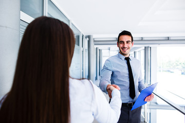 Young colleagues shake hands after a successful job