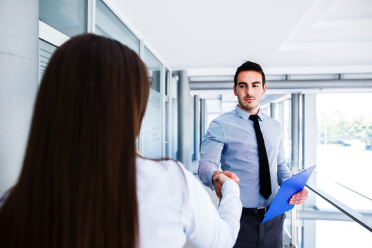 Young colleagues shake hands after a successful job