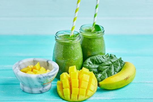 Mango With Banana And Spinach Smoothie On Blue Wooden Table.