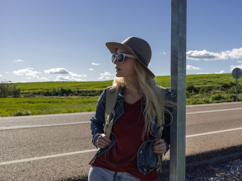 Woman leaning on post on roadside