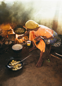 Rural african villager making bread and cooking in her kitchen