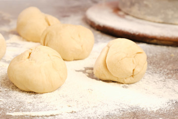 Unleavened dough for tortillas with flour and hand on kitchen table. Cooking burrito.