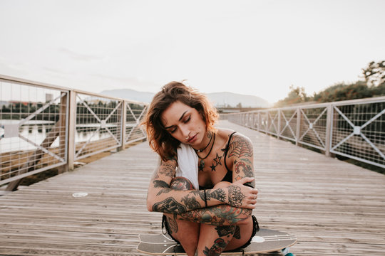 tattoed woman with her skate on a wooden runway