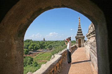 A young female backpacker looks out across the vast plains of Bagan in Myanmar