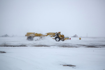 Clearing airport from snow during snow storm. clearing runway from snow. Clearing snow with bulldozers from airport aprons.