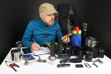 bearded man the traveler collects things for a hike on the nature