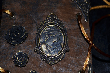 Obraz premium Closeup of a cameo and roses on an old-looking handmade notebook