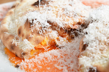 Italian pizza calzone on white plate   