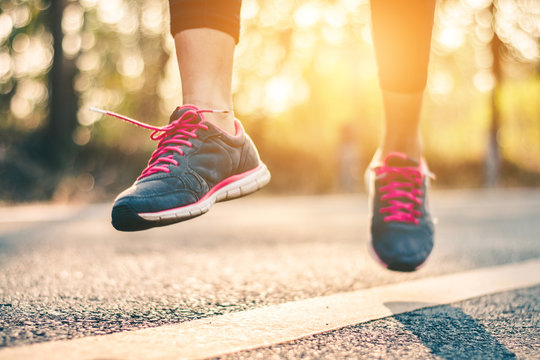 Women runner feet on road in workout wellness concept.
