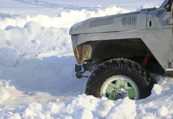 the wheel of the car is stuck in the snow. spray of snow from the rotating wheel of winter tires. slipping machine in the snow. the machine is in captivity of a snowdrift after a snowfall.