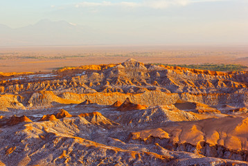Sunset over Atacama Desert panorama in San Pedro, Chile. Rock formation patterns left by volcanic activity of the past in the desert vastness.