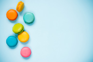 Colorful macaroons arranged over blue background. Copy space.
