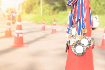 silver metal with symbol of running athlete. medals on road cones. victory or trophy concept photo