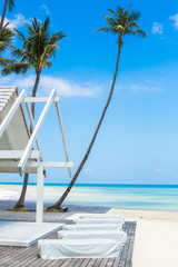a landscape photo of the sea shore and a wooden house with a playground for sun beds. concept of summer holidays on the ocean