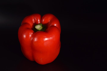 Bright red peppers on a seamless black background. 