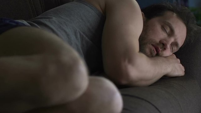 Drunk man sleeping on living room sofa in underwear, lazy bachelor lifestyle