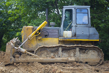 Obraz premium Bulldozer transports the ground.Construction excavator digging in the ground at the construction site.Slow motion shot.