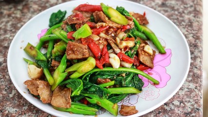 Cooking food fried meat and Chinese kale green vegetarian with Chilli Garlic thai styl