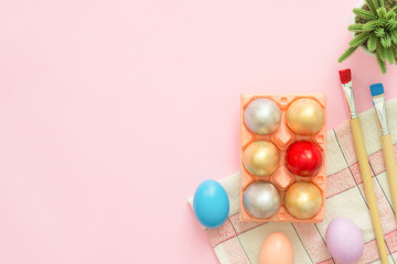 Flat lay top view colorful easter egg painted in pastel colors composition with paint brush on pink pastel color background. Easter day background top view with copy space.