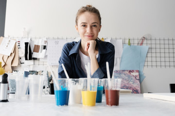 Young female artist painting abstract acrylic canvas in studio
