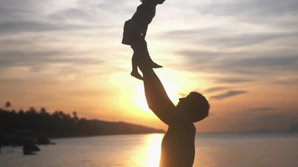 Young father and daughter spending happy time at the beach during amazing sunset. slow motion. 3840x2160