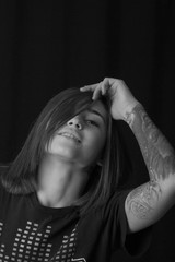 Portrait of beautiful teenager in t-shirt looking up while posing on dark background