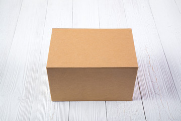 Empty Package brown cardboard box or tray on bright wooden table with copy space.