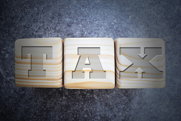 Tax - text on wood texture blocks on dark grey background. Wooden blocks with letters and word..