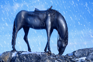 Fototapeta na wymiar sculpture of a horse in the mountains against the sky. snow