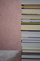 Stack of book on grunge gray brown table on light pink background. Education concept.