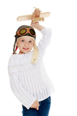 Little girl with a wooden plane in her hand.