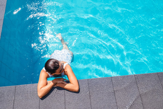 Woman swim in swimming pool at sunny day