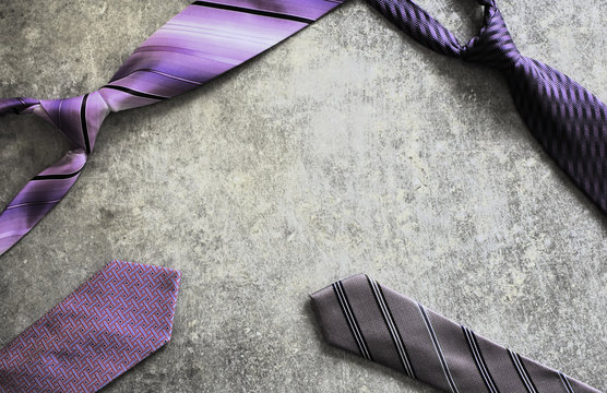 Four purple violet patterned ties on grey grunge scratched table background. Happy Fathers Day composition for greeting card. Top view image with copy space for text.