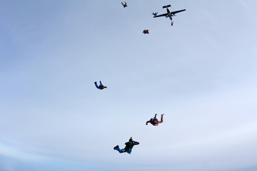 Skydivers are jumping out of a plane.