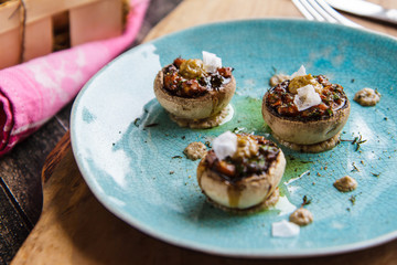 Stuffed mushrooms on a ceramic turquoise plate closeup