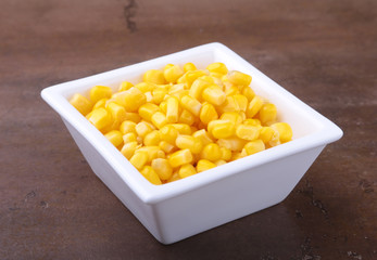 Sweet canned corn in white bowl. Ingredients for salad. Selective focus.