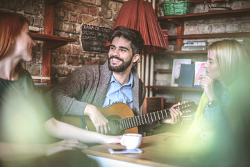 Man play music on his guitar for friends.