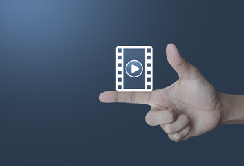 Play button with movie icon on finger over light gradient blue background, Cinema online concept