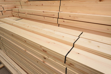 Many folded wooden planks in a warehouse with a forest