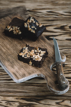 Pieces of delicious chocolate brownies on a wooden background