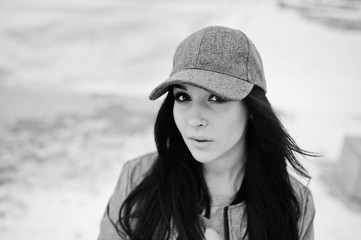 Stylish brunette girl in gray cap, casual street style on winter day.