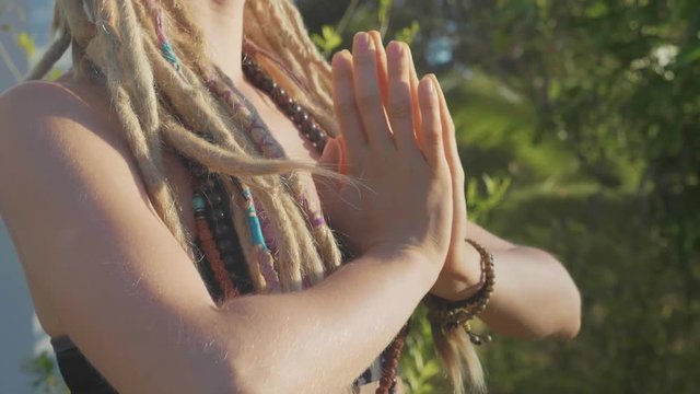 Young woman doing asana yoga with namaskar gesture at backyard of her house