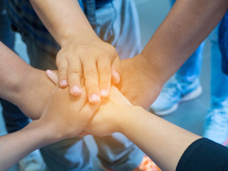 Closeup image of many people hands in circle together with sunlight effect. Teamwork Concept.