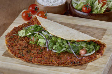 Turkish Food: lahmacun closeup on a wooden table. Horizontal
