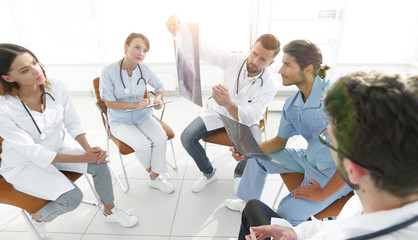 radiologists and a surgeon discussing a radiograph of a patient