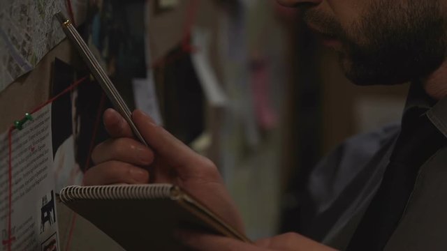 Officer looking at city map and making notes, defining possible crime place