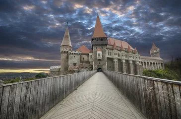 Photo sur Plexiglas Château Le château de Corvin, également connu sous le nom de château de Hunyad ou château de Hunedoara, est un château gothique-Renaissance à Hunedoara, dans la région de Transylvanie, en Roumanie, au coucher du soleil.