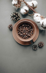 Cup of black coffee, coffee beans and cotton flowers on dark background