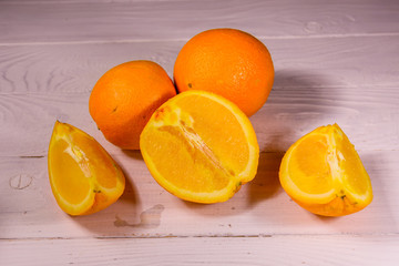 Whole and sliced oranges on a wooden table
