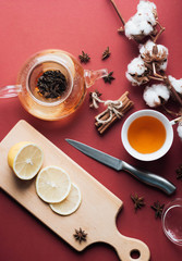 Obraz na płótnie Canvas Close-up view of tea in glass pot, lemon, cotton flowers, cinnamon and lemon